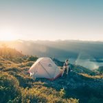 Lever de soleil sur un campeur au milieu des montagnes